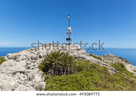 Antenna on the mountain. Metal antenna on the rocky beach of Majorca with blue sea on background. 