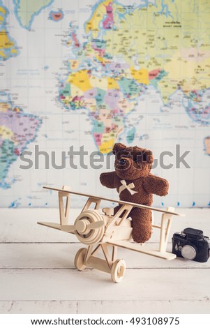 teddy bear and wooden toy airplane with world map, Travel concept
