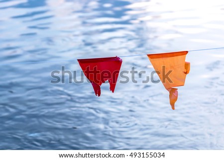 The color flag lacking hang over water. Selective focus on flag