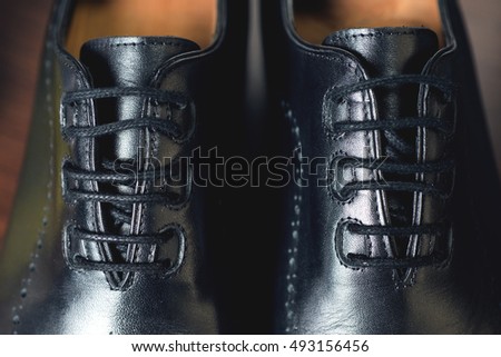 Close up picture of leather men's shoes on wooden background