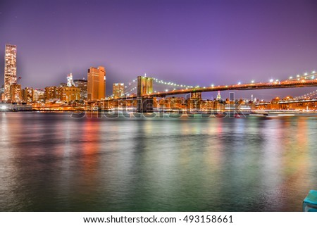 New York City Manhattan skyline panorama at night over Hudson River with refelctions viewed from New Jersey. long exposure