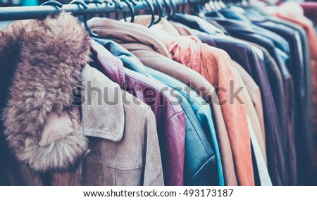 Selective focus second hand of Winter clothes hanged on a clothes rack , retro picture style Royalty-Free Stock Photo #493173187