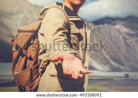 Young travel man lending a helping hand in outdoor mountain scenery. Royalty-Free Stock Photo #493188091