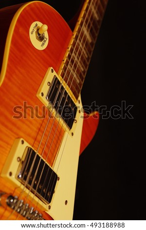 Vintage electric guitar closeup on the black background. Shallow depth of field.