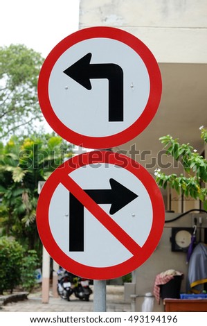Traffic signs turn left and do not turn right next to building