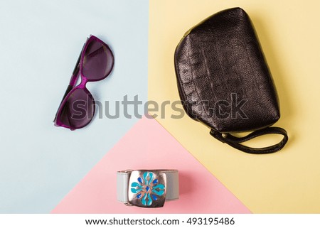 Bag and cosmetics on an abstract background.