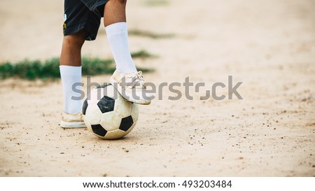 A kid is playing football : Picture with space.