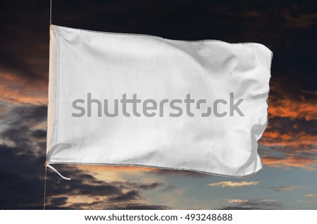 white flag waving on a storm cloudy sky