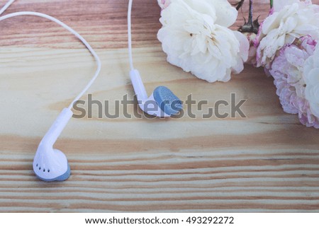 flowers and headphone in the wooden background