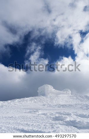 Winter landscape with a beautiful texture of the snow. The old observatory on the top of the mountain. Sunny day. Carpathians, Ukraine, Europe