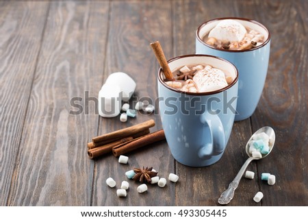 Blue Cups of hot Chocolate drink with Marshmallows and cinnamon on dark wooden background. Winter time. Holiday concept, Selective focus