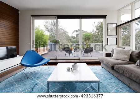 Luxury scandinavian styled living room with outlook to terrace and gum trees