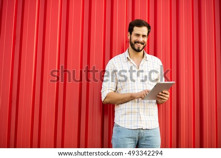 smiling man with tablet on red background