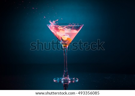 Colorful Pink Cocktail With Lemon Splashing In Martini Glass On Background At Party. Selective Focus.