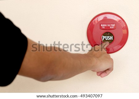 closeup shot of human hand pushing fire alarm. The hand of man is pushing fire alarm switch on the wall. 
