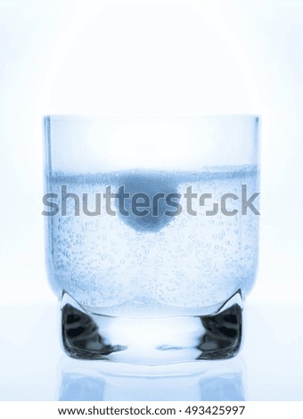 aspirin tablet in a glass of water, white background