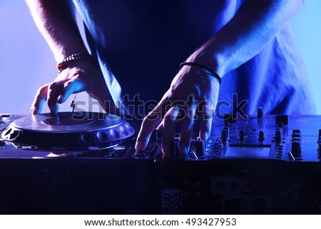 DJ mixing tracks on a mixer in a nightclub Royalty-Free Stock Photo #493427953