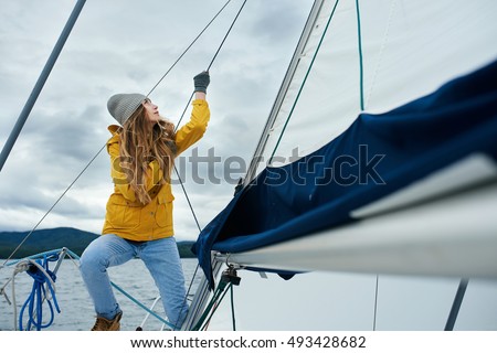 Young strong woman sailing the boat Royalty-Free Stock Photo #493428682