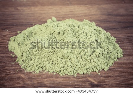 Vintage photo, Heap of young powder barley on wooden background, healthy nutrition and lifestyle, body detox