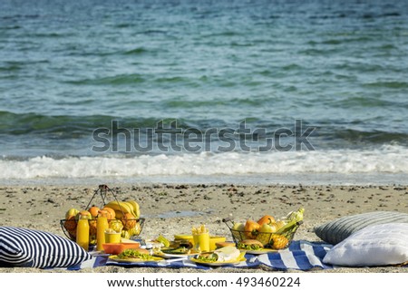 Summertime. A picnic on the beach. Burgers and pitas, vegetables and fruits. Selective focus.