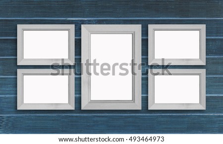 Collage of five photo frames on painted dark navy panels wall