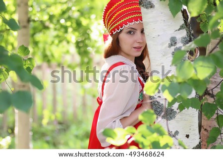 Slav in traditional dress hiding behind trees