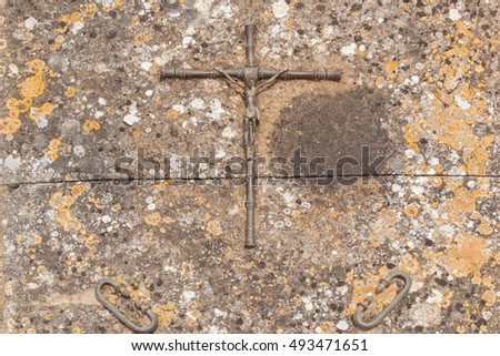 Metal cross. Close up photo of crucifix of Jesus Christ on the stoned plate. 