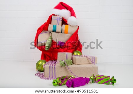 bag with gifts on the table around the decorations for the Christmas tree