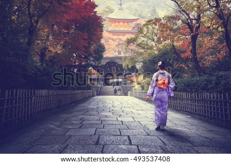 Japanese woman walking to red pagoda, Japan