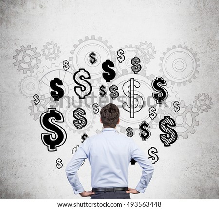 Rear view of businessman in blue shirt standing near concrete wall with dollar sign sketches and gears. Concept of money should work