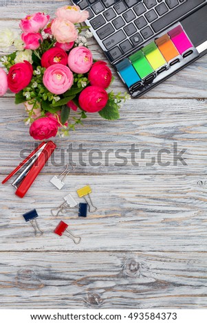 stationery, flowers and laptop on old boards, flat lay