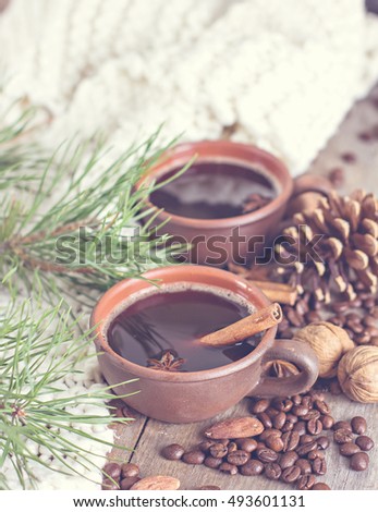 Coffee, fir branch, nuts, cones, cozy knitted blanket. Winter, New Year, Christmas still life.