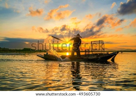 Fishermen fishing in the early morning golden light.Fishermen on a fishing boat.Fishermen are casting nets.Sparkling water .Beautiful sunset.Beautiful sunrise.