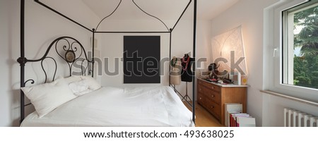 Interior, lovely bedroom with double bed in wrought iron