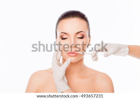 Doctor in gloves  giving woman botox injections in lips