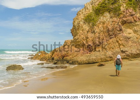 Man with backpack at rocky beach in Praia Malhada, Jericoacoara, Brazil
