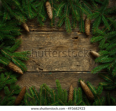 Christmas tree branches with cones on wooden texture ready for your design. Winter holidays background