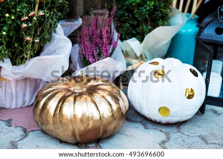 Halloween pumpkins painted in white and gold. Holiday decoration.
