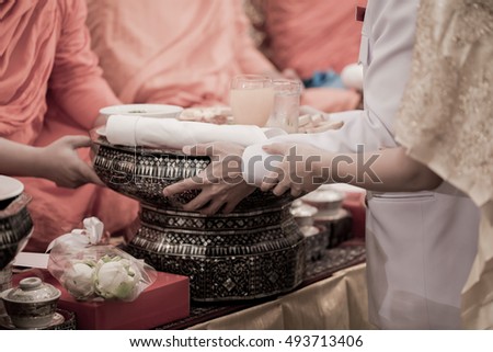 Hands of newlyweds who are offering food to the monks.
