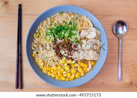 Instant noodles with chicken,corn,onion in  bowl on wood background