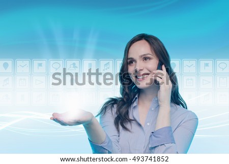 Young woman using mobile phone, digital icons behind her, light beam coming from open hand