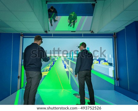 Engineers inspecting factory layout in 3D in virtual reality suite