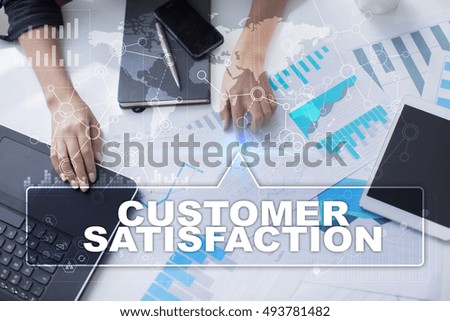 Woman is working with documents, tablet pc and notebook and selecting "Customer satisfaction".