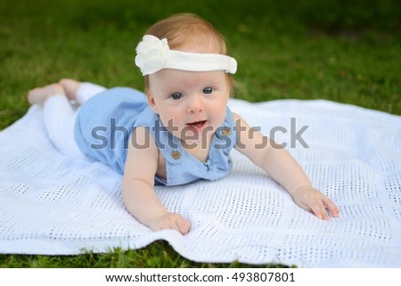 Little baby girl lying in the grass