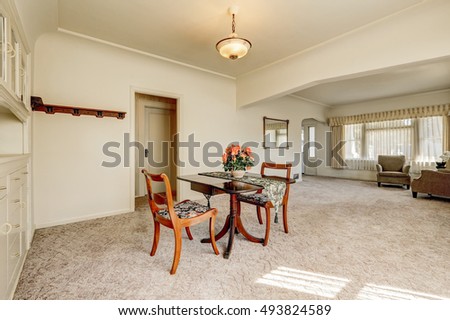 Interior of retro style dining room with carpet floor and wooden table set for two person. Northwest, USA