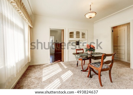 Interior of retro style dining room with carpet floor and wooden table set for two person. Northwest, USA