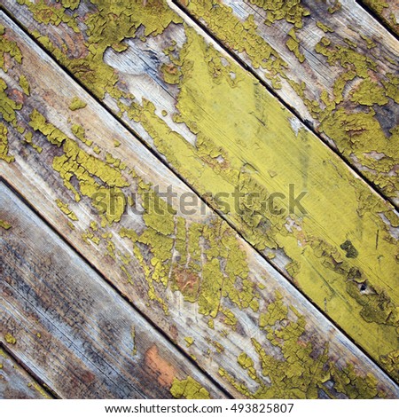 Dry yellow paint on the wooden surface. Peeling. Cracked texture. Abandoned place decoration. Toned image. Scratched background. Toned. Old colorful wall. Close up photo.