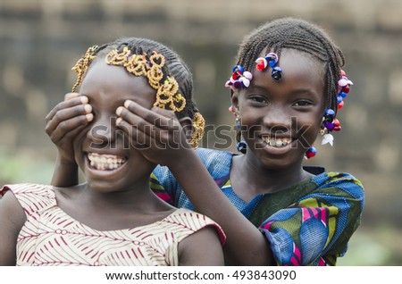 African Girls Playing Peekaboo Outdoors Laughing and Smiling Together (Happiness Symbol) Royalty-Free Stock Photo #493843090