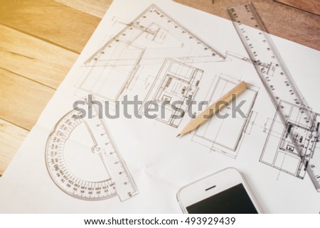 blur image of perspective design paper,blur image of design with Pencil and a ruler on top of a wooden floor plan.