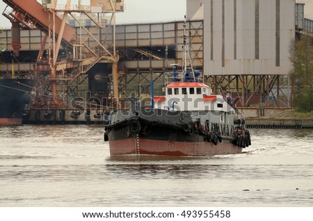 The picture shows a tug working in the port.